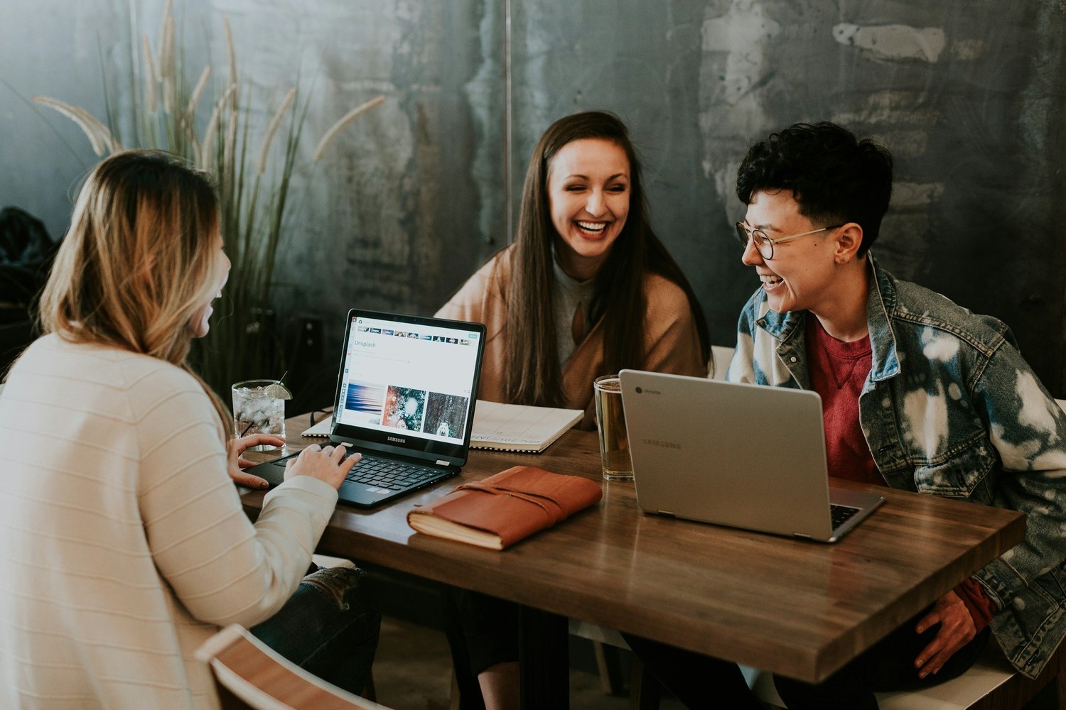 Colleagues smiling together over their laptops
